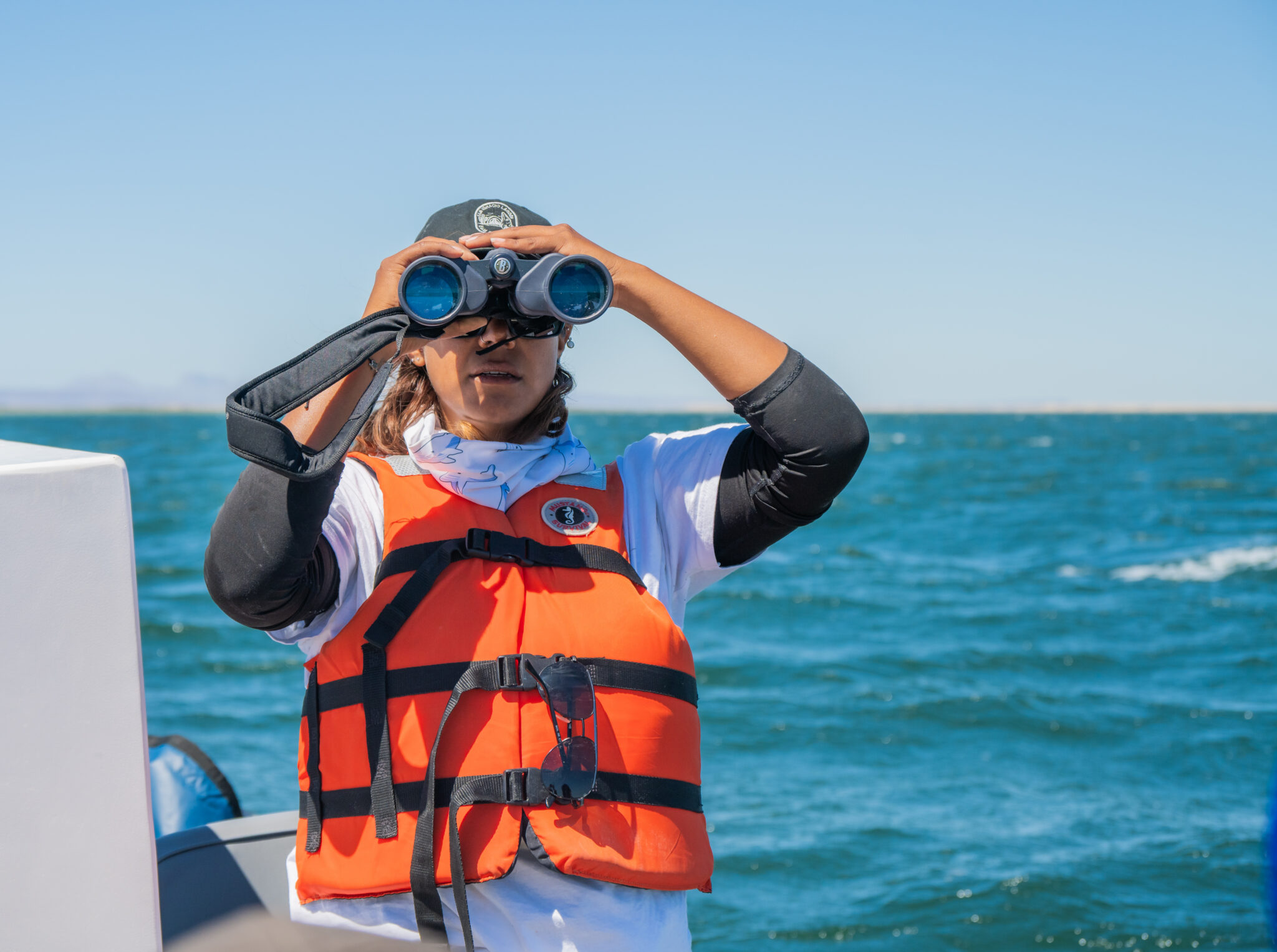 Whale watching through binoculars at San Ignacio Lagoon, side-profile