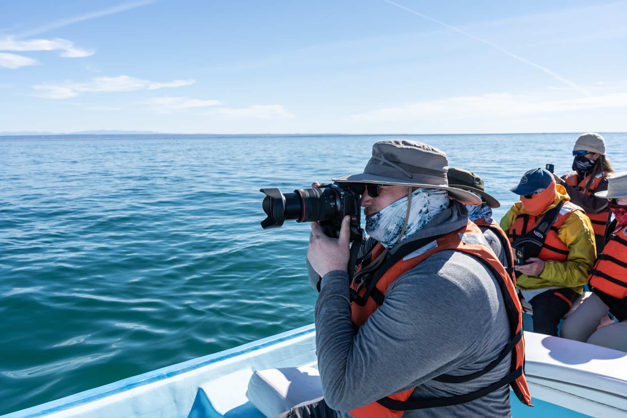 Guest using zoom camera to photograph gray whales in San Ignacio Lagoon